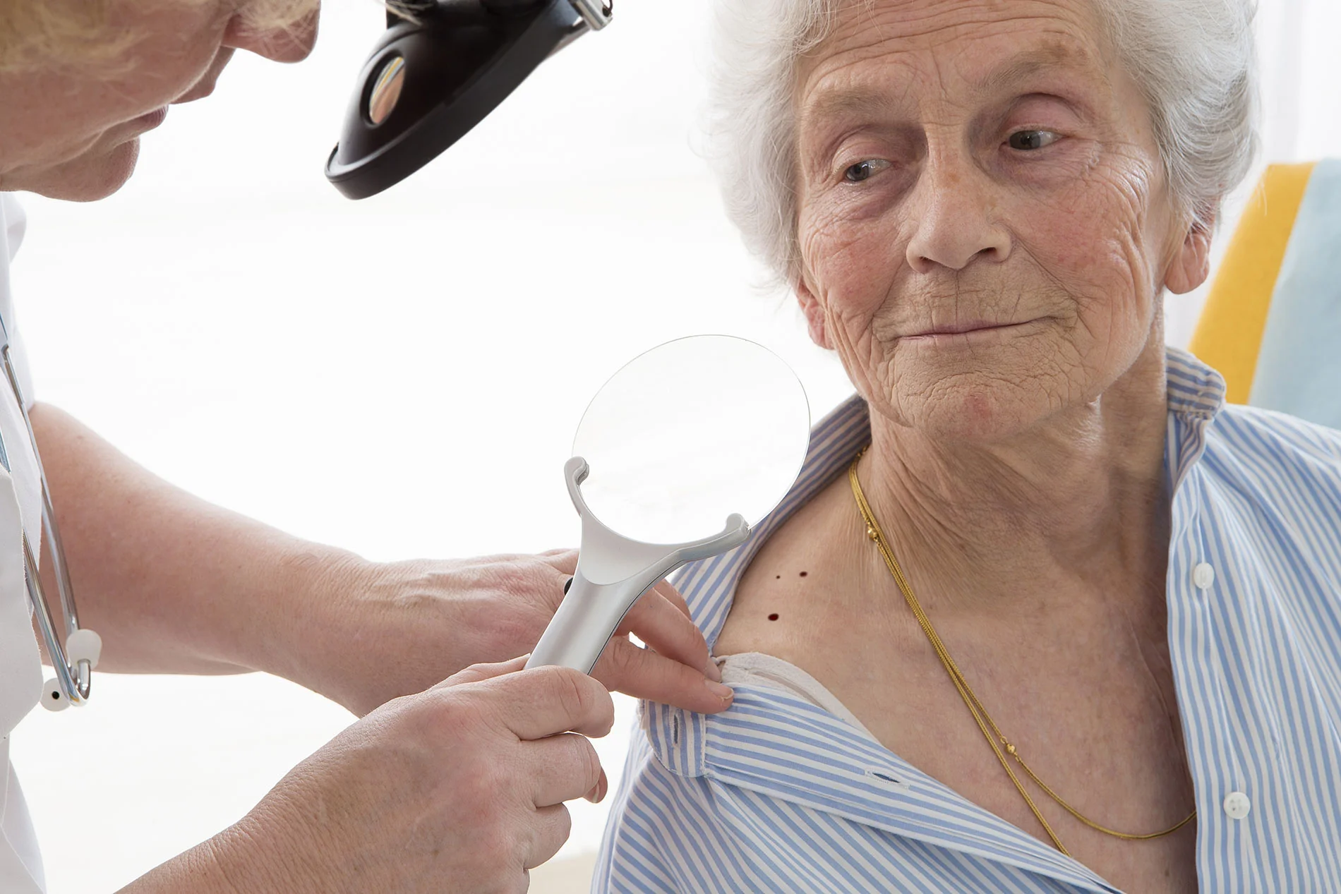 Mature person having skin examined